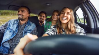 Des jeunes en voiture conduient par une jeune conductrice qui vient d'avoir son permis de conduire