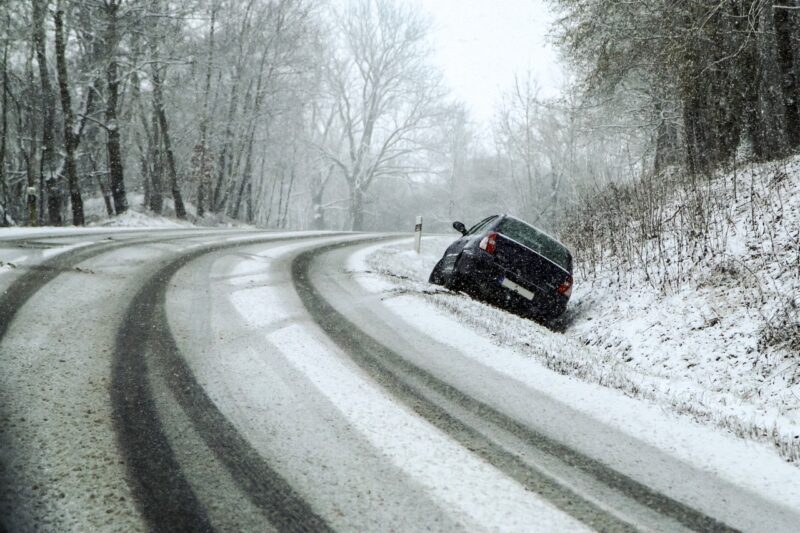 Une voiture dans le fossé après avoir glissé sur la neige alors qu'elle avait des pneus été