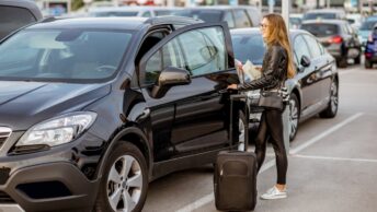 Une jeune femme récupère une voiture qu'elle vient de louer lors de ses vacances