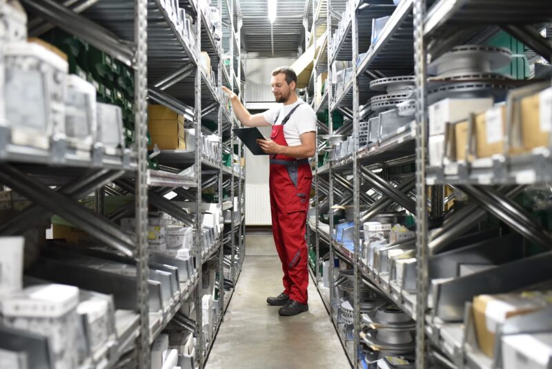 Un magasinier dans un rayonnage de stockage de pièces de voitures